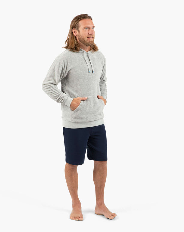 Active dude in gray hoodie and navy shorts, showcasing comfort and style for gym and beach activities.
