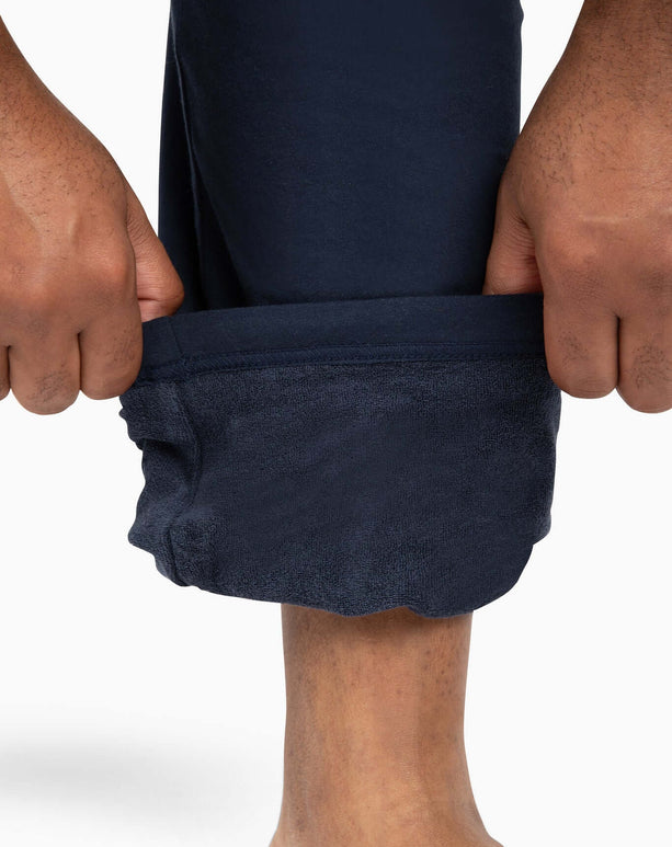 DudePants featuring hands pulling up the towel-lined cuff for easy on and off, perfect for active lifestyles.