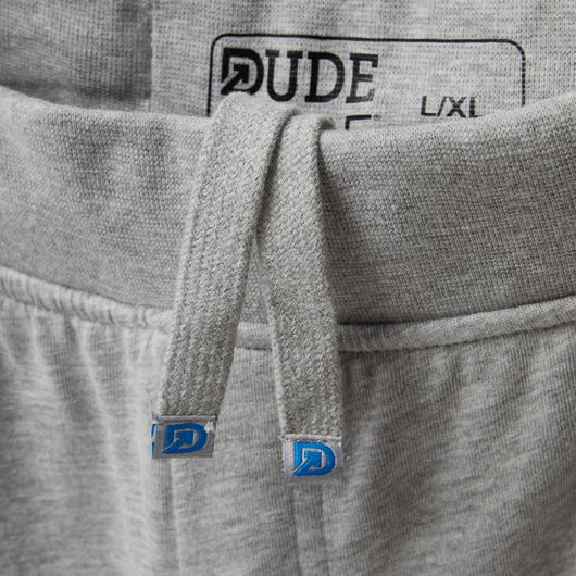 Close-up of The Pants showing premium logo'd drawstrings and waistband for men's sweatpants.