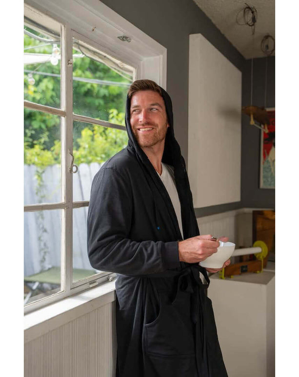 Man wearing The DudeRobe luxury hooded bathrobe while enjoying breakfast at home.
