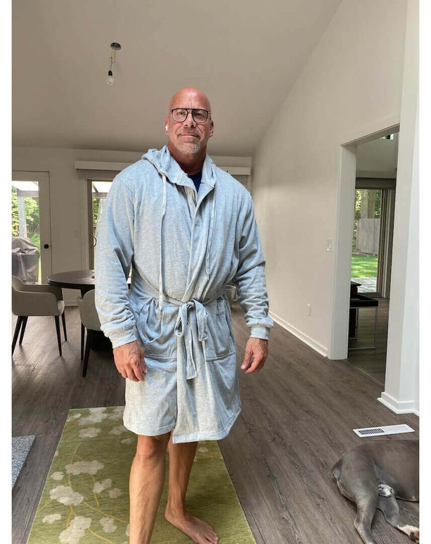 Man wearing The DudeRobe luxury hooded bathrobe, showcasing comfort and style in a modern home setting.