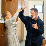 Kids DudeRobe fun time with father and son covered in foam, showcasing a boys hooded robe and kids robe.