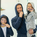 Kids DudeRobe worn by a father and his children, showcasing a cozy morning routine with smiles and toothbrushes.