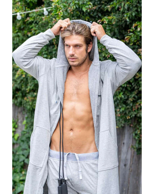 Stylish man in a grey luxury bathrobe with shorts, showcasing modern comfort and style for lounging.