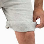 Man adjusting the cuff of The Shorts, showcasing comfort and style in activewear.