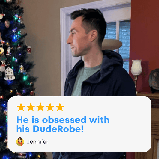 Man wearing his DudeRobe stands beside a decorated Christmas tree, showcasing the stylish mens hooded bathrobe.