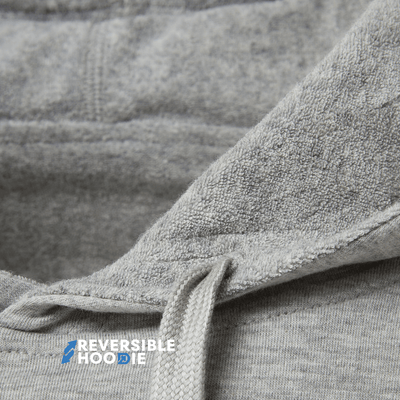 Close-up view of fabric detailing on a gray reversible hoodie for men.