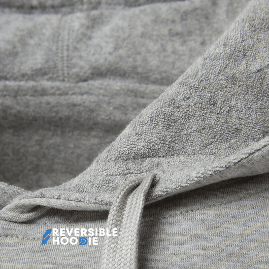Close-up view of fabric detailing on a gray reversible hoodie for men.