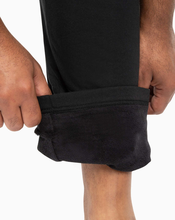 Close-up of hands rolling up DudePants, showcasing towel lining and relaxed leg holes for comfort and easy wear.