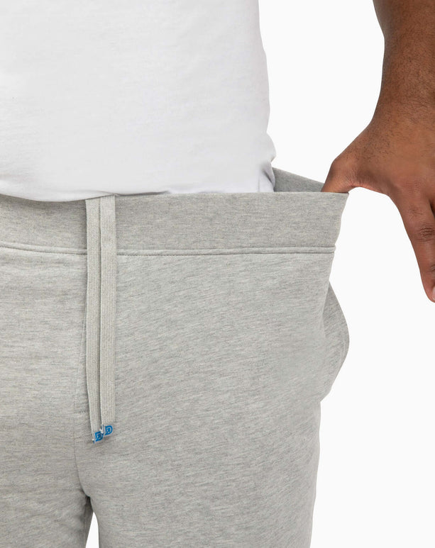 Close-up of a man showing the extra deep pockets and premium waistband of DudeShorts.