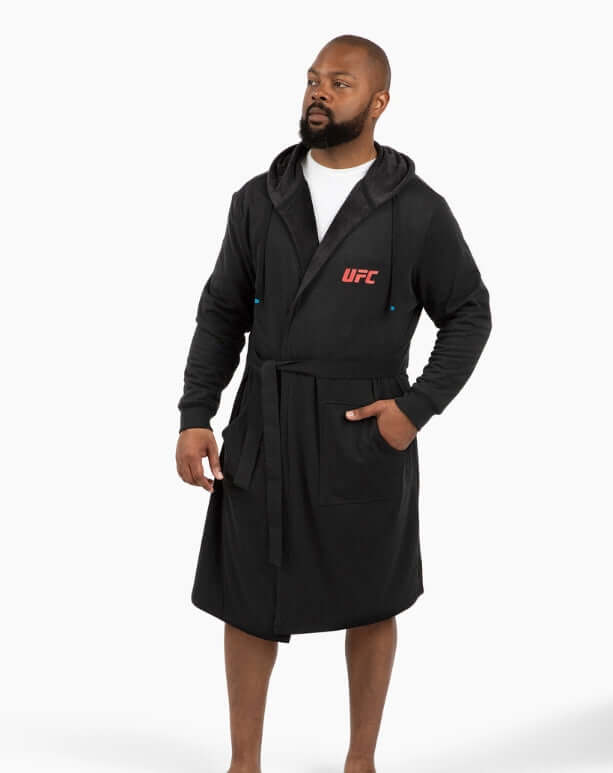 Man wearing UFC DudeRobe in black, featuring a hood and modern design, perfect for lounging and comfort.