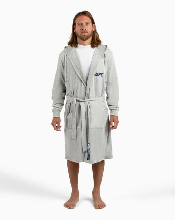 Man wearing grey UFC DudeRobe, showcasing modern design and comfort for lounging or post-shower relaxation.